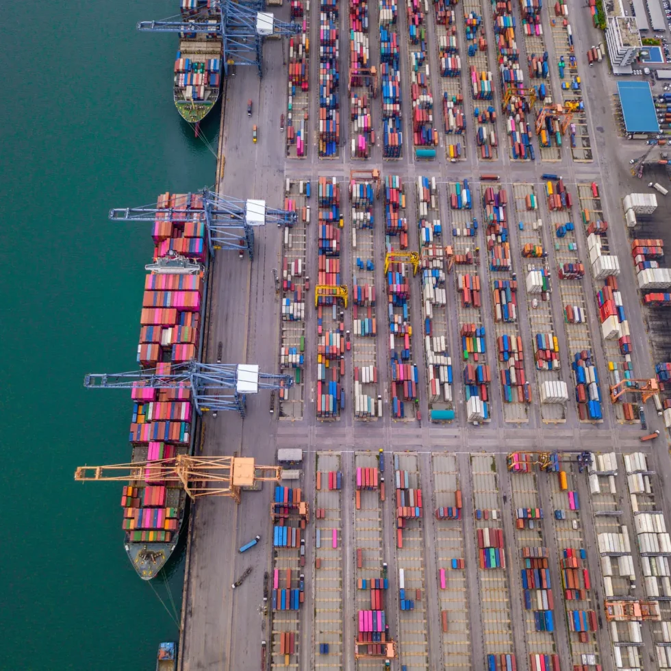 Aerial view of container port with cargo ships and stacked shipping containers